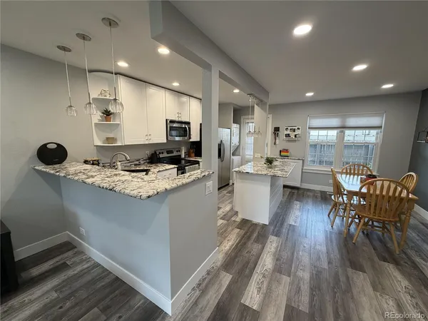 a kitchen with counter space wooden floor and stainless steel appliances