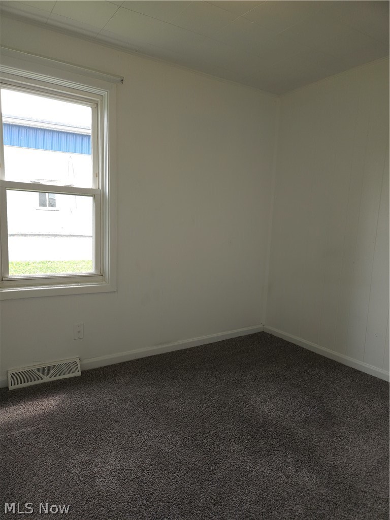 4660 Darrow Road Stow, OH 44224 - Photo 15 of 25 Neutral wall paint, window with white trim, dark grey carpet, and white ceiling