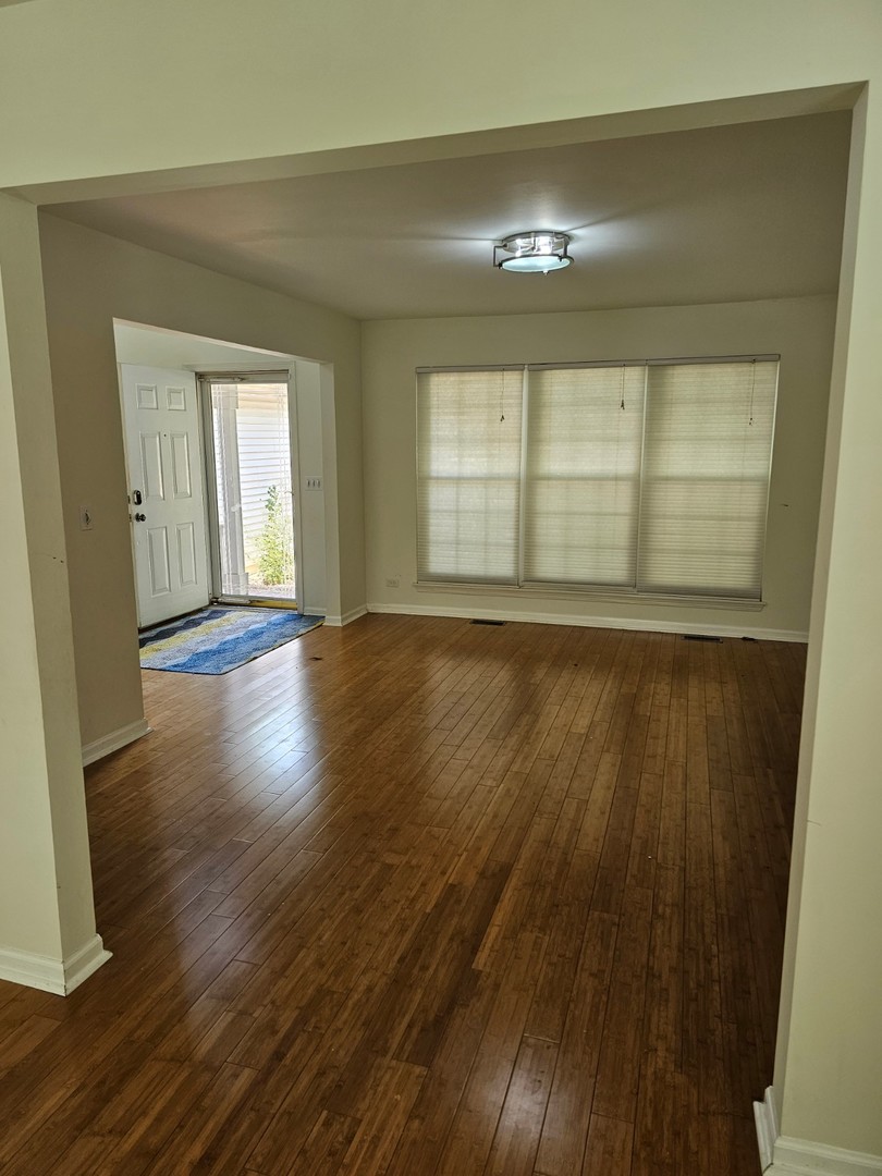 847 Teasel Lane Aurora, IL 60504 - Photo 3 of 19 a view of an empty room with wooden floor and a window