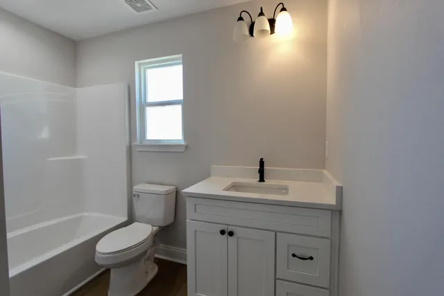 a bathroom with a sink toilet tub and vanity