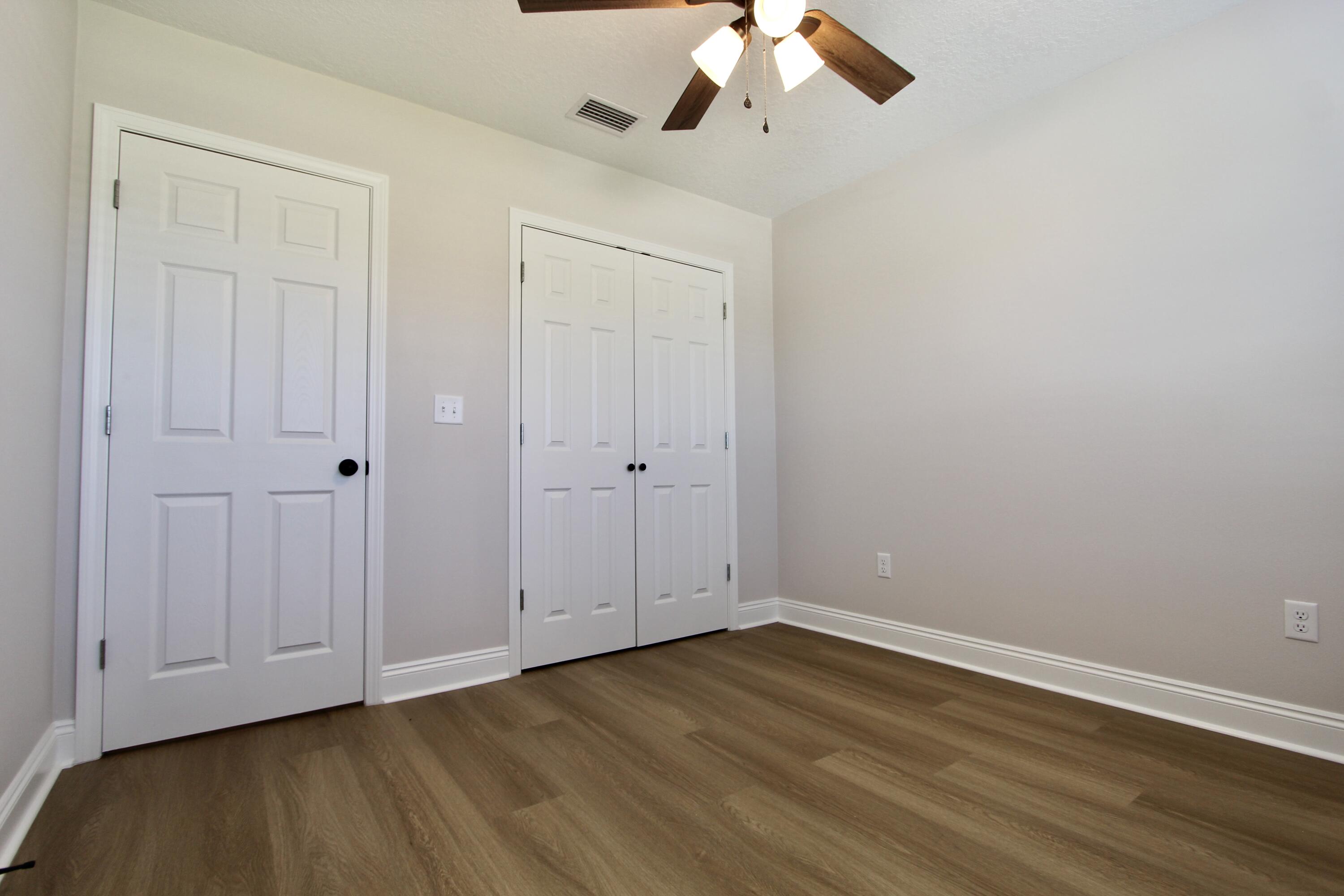 4610 Bobolink Way Crestview, FL 32539 - Photo 13 of 25 a view of an empty room with wooden floor