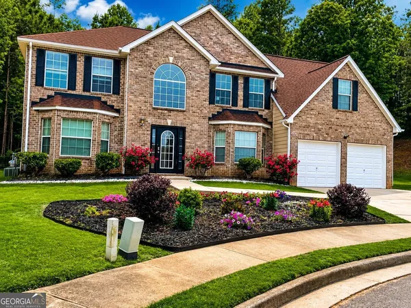 a front view of a house with a yard and outdoor seating
