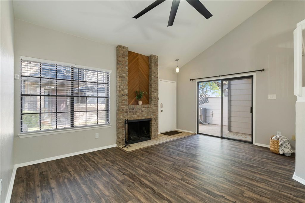 1748 Ohlen Road, Unit 76 Austin, TX 78757 - Photo 11 of 34 an empty room with windows fireplace and wooden floor