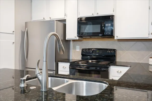 a kitchen with a refrigerator a microwave and wooden floor