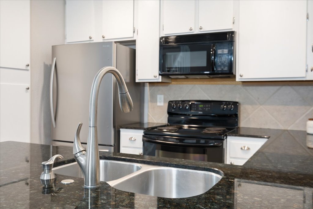 1748 Ohlen Road, Unit 76 Austin, TX 78757 - Photo 14 of 34 a kitchen with a sink a stove and a microwave