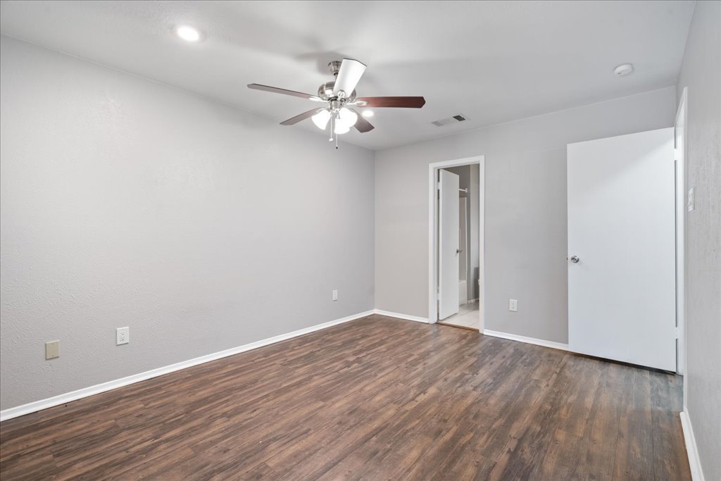 1748 Ohlen Road, Unit 76 Austin, TX 78757 - Photo 21 of 34 an empty room with wooden floor fan and windows