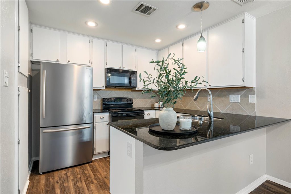 1748 Ohlen Road, Unit 76 Austin, TX 78757 - Photo 4 of 34 a kitchen with stainless steel appliances granite countertop a refrigerator a stove a sink and a granite counter tops