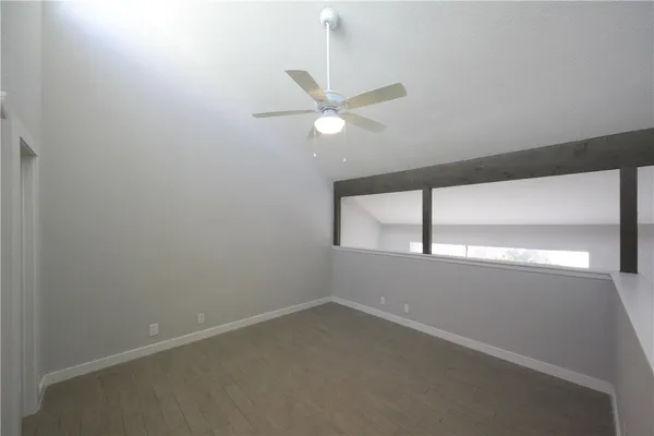 an empty room with a window and a fan
