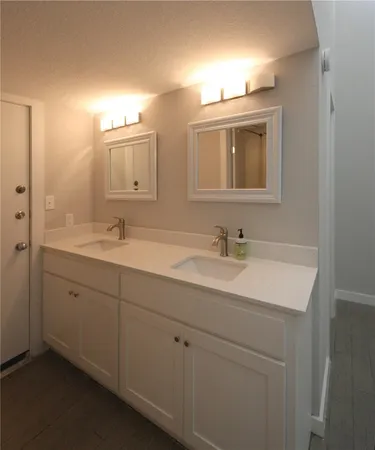 a bathroom with double sink and a mirror