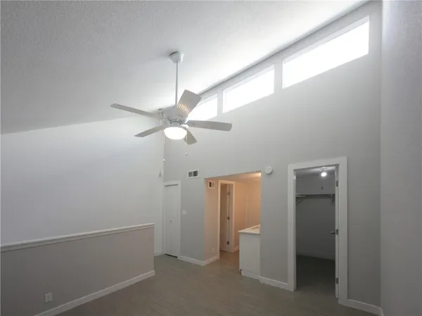 a view of a hallway with a chandelier fan