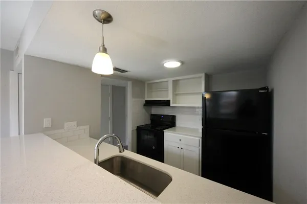 a kitchen with a refrigerator and a sink