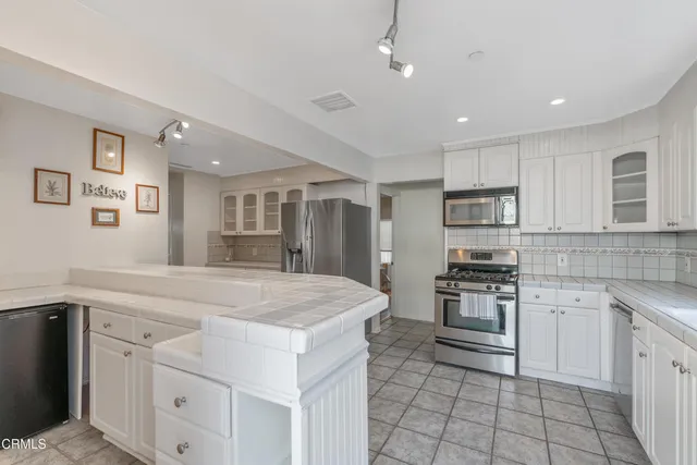 a kitchen with stainless steel appliances kitchen island granite countertop a sink and cabinets