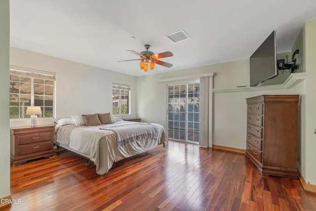 a spacious bedroom with a bed and wooden floor