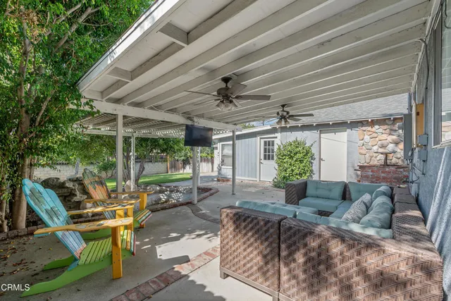 a living room with patio furniture and a garden