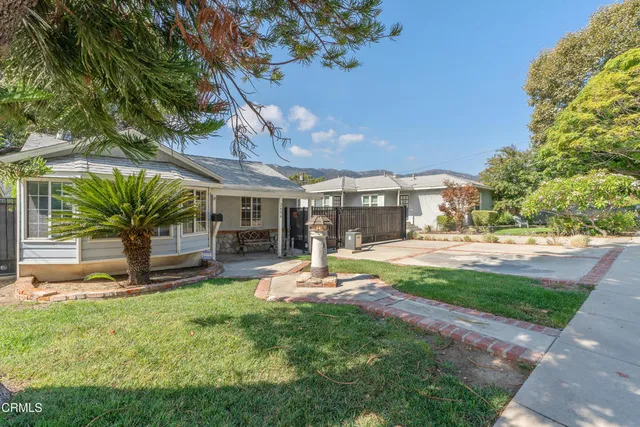 a view of a house with backyard and sitting area