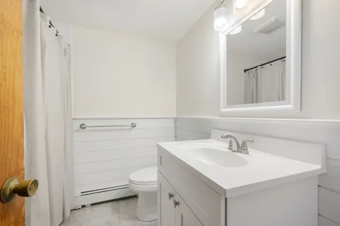 a bathroom with a sink mirror and toilet