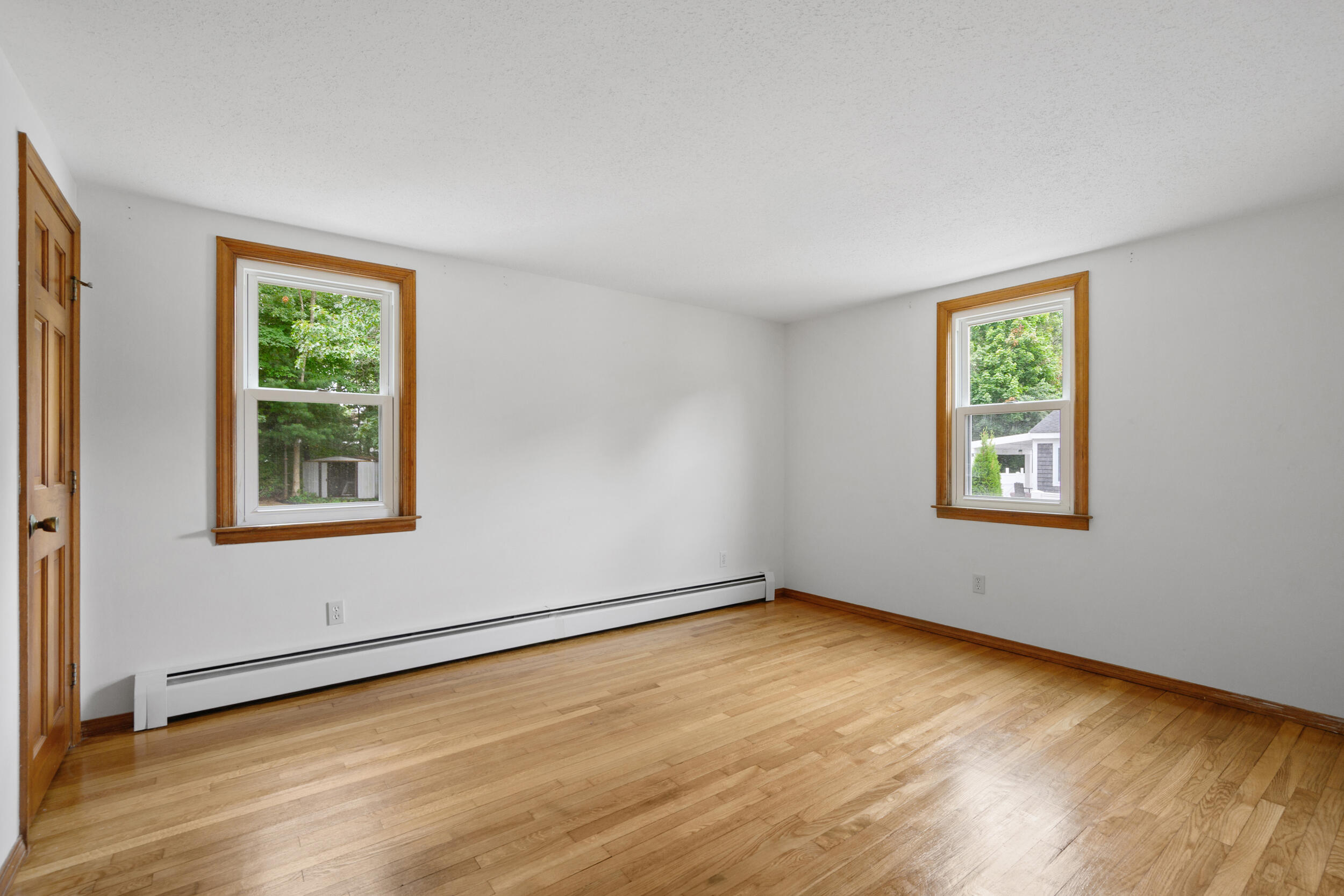 296 Buckskin Path Centerville, MA 02632 - Photo 14 of 34 a view of an empty room with a window and wooden floor