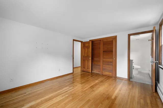 an empty room with wooden floor and closet