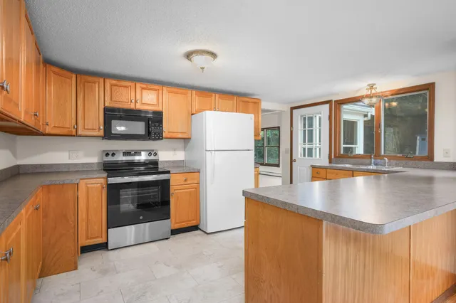 a kitchen with stainless steel appliances granite countertop a refrigerator stove top oven a sink and dishwasher