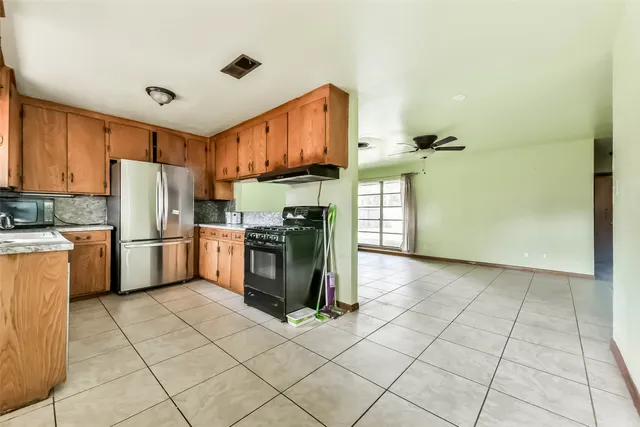 a kitchen with a refrigerator a stove top oven and cabinets