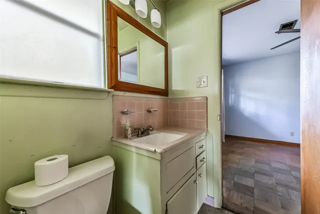 a bathroom with a toilet sink and mirror