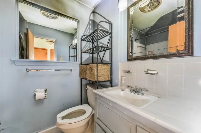 a bathroom with a toilet sink and mirror