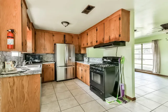 a kitchen with a stove top oven sink and cabinets
