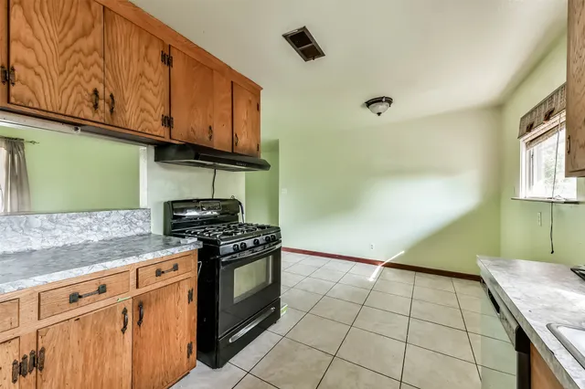 a kitchen with granite countertop a stove a sink and dishwasher