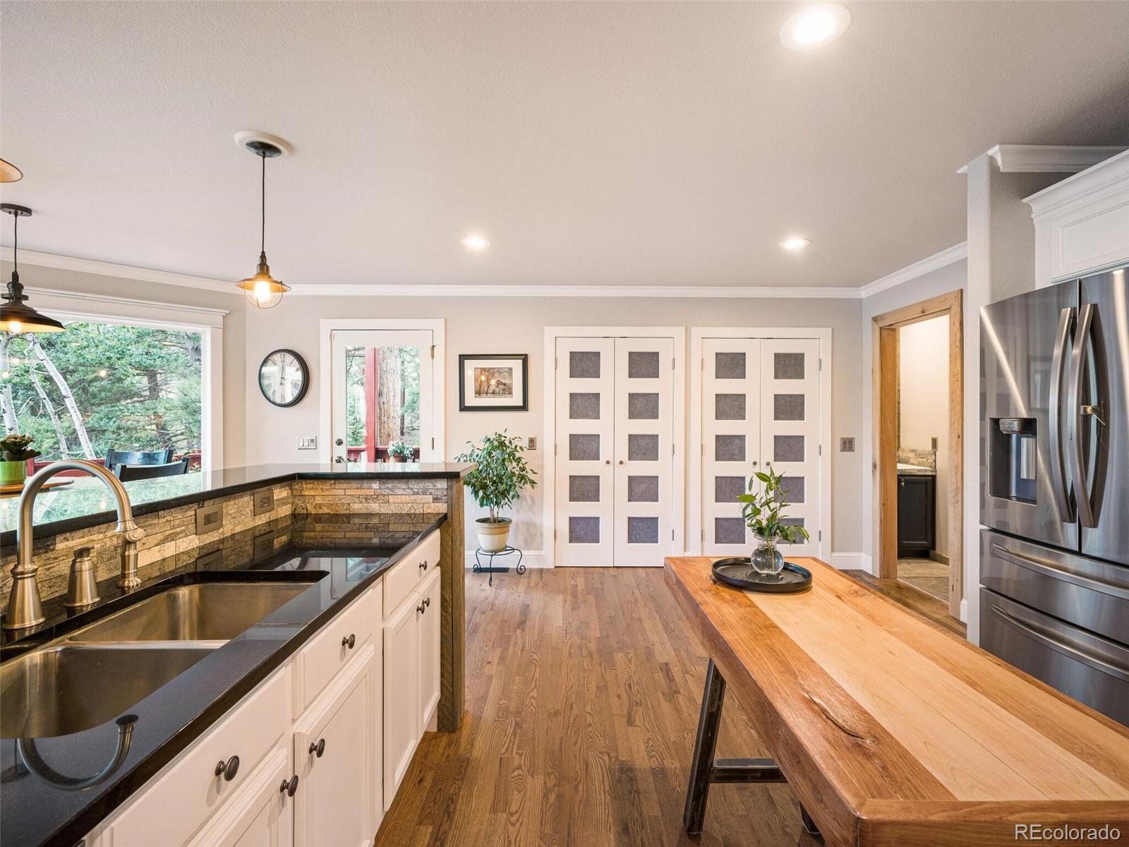 137 Nuthatch Road Evergreen, CO 80439 - Photo 16 of 50 a open kitchen with kitchen island a large window cabinets a sink and stainless steel appliances