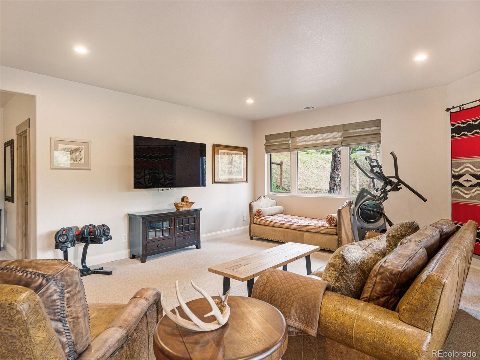 137 Nuthatch Road Evergreen, CO 80439 - Photo 35 of 50 a living room with furniture and a flat screen tv