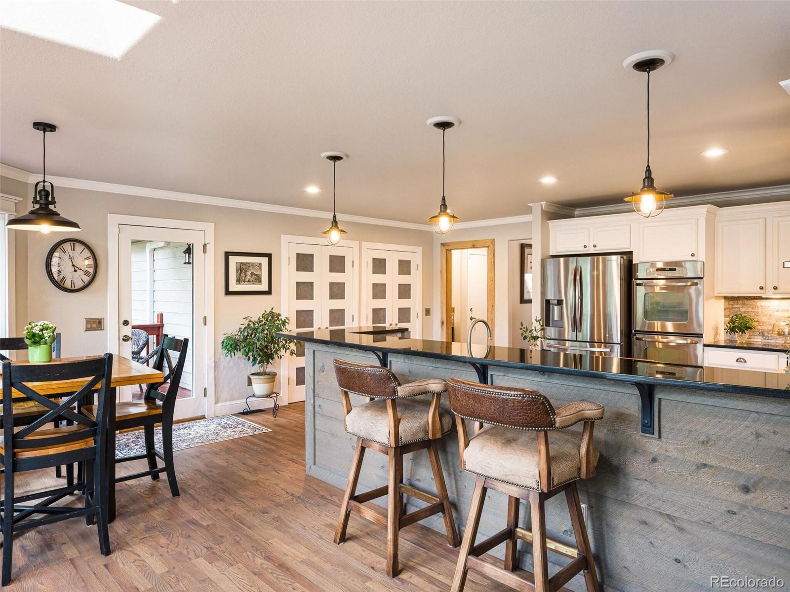137 Nuthatch Road Evergreen, CO 80439 - Photo 7 of 50 a view of a dining room and livingroom with furniture wooden floor a chandelier