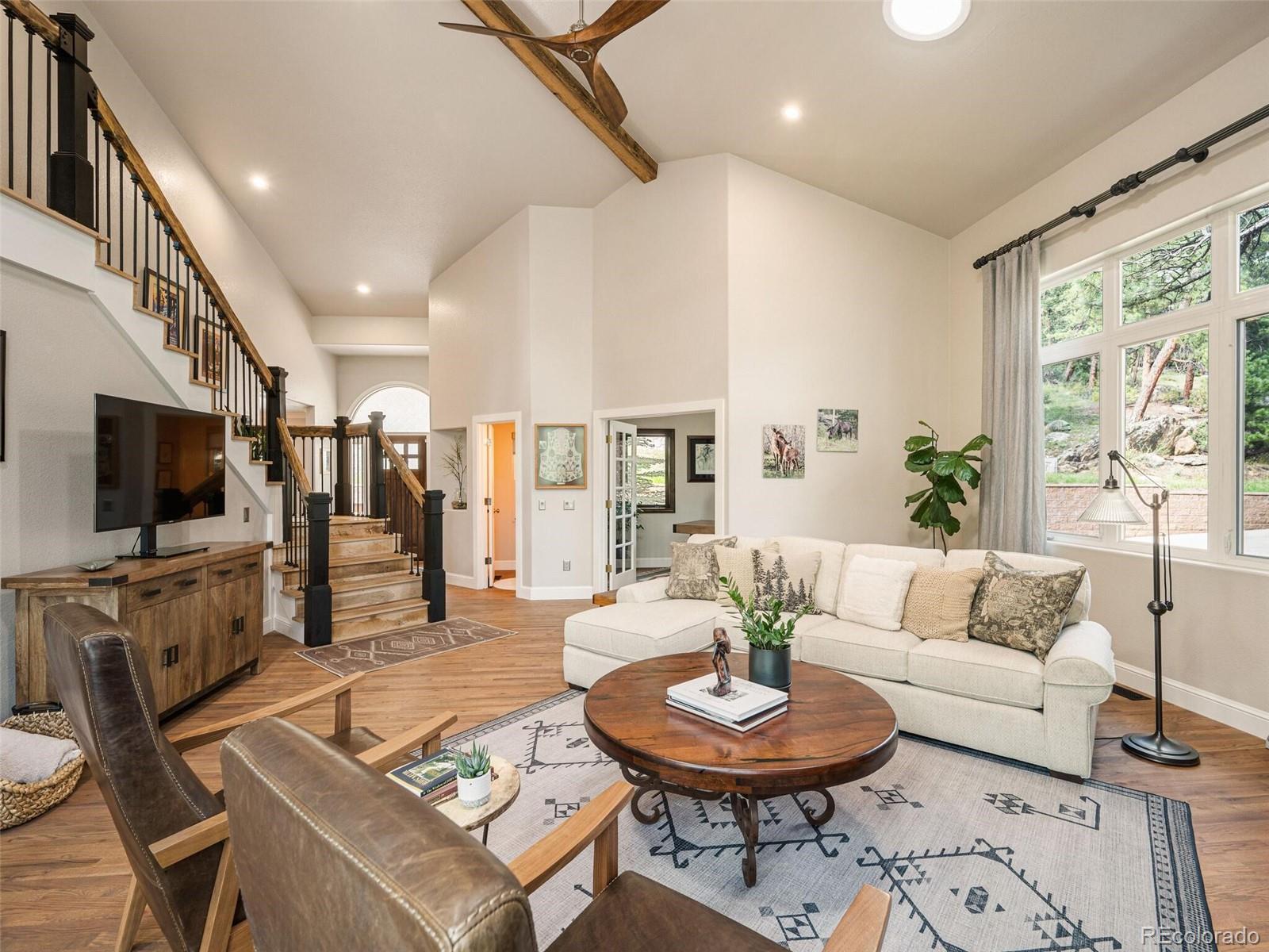 137 Nuthatch Road Evergreen, CO 80439 - Photo 8 of 50 a living room with furniture a flat screen tv and a large window