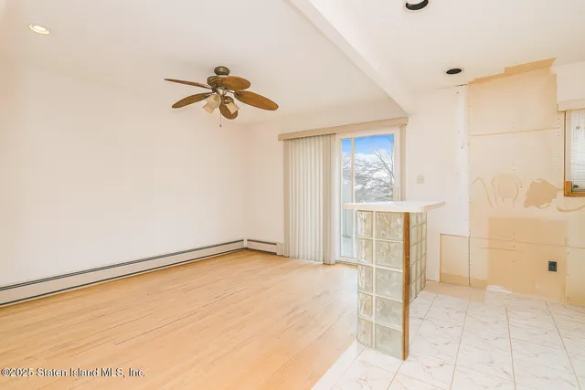 a view of a room with a ceiling fan and window