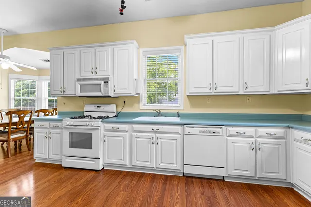 a utility room with cabinets and wooden floors