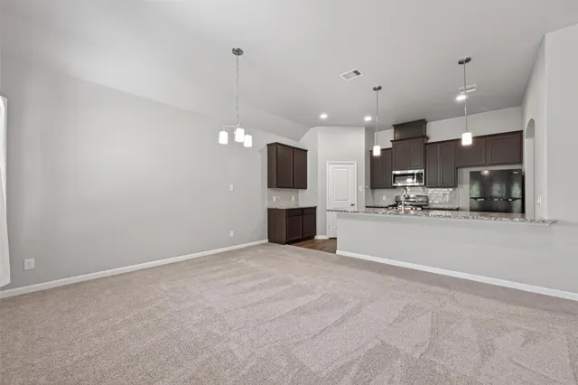 a kitchen with kitchen island granite countertop a stove top oven a sink and dishwasher