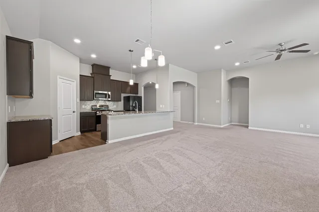 a kitchen with stainless steel appliances granite countertop a stove a sink and a refrigerator