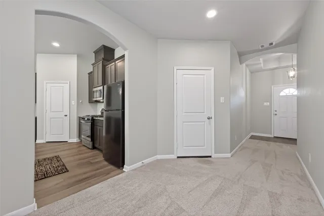 a view of an empty room and kitchen view