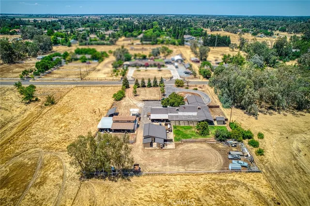 a living room with furniture a chandelier and a dining table with wooden floor