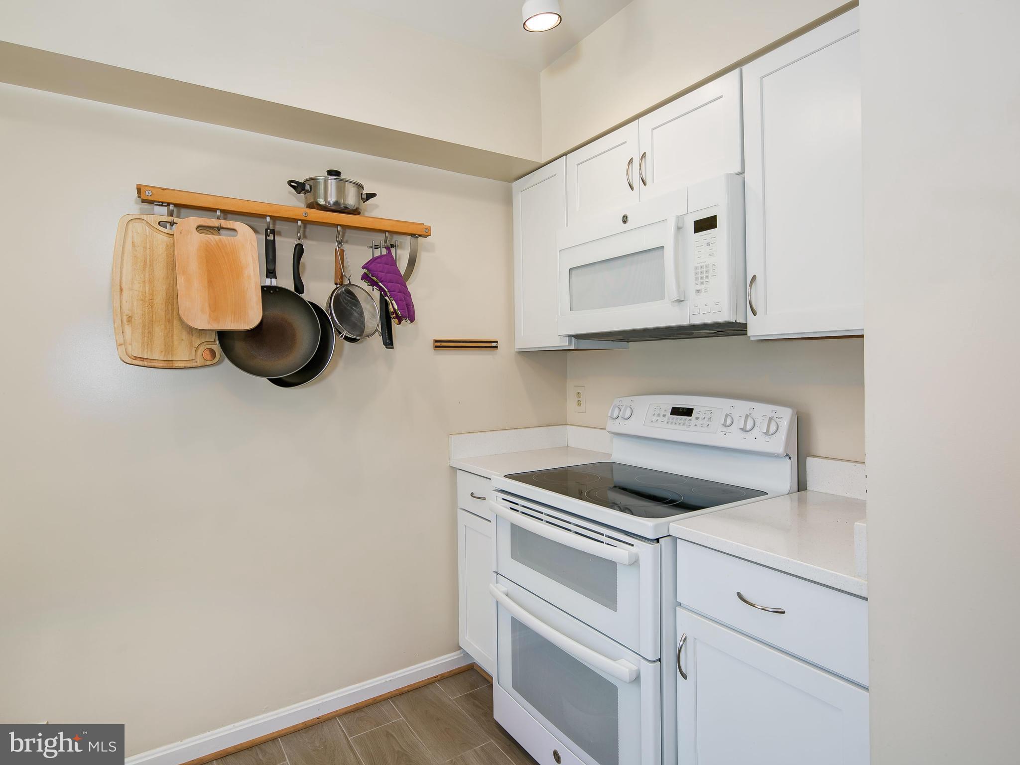 3851 Porter Street Northwest, Unit D280 Washington, DC 20016 - Photo 14 of 22 a kitchen with white cabinets and white appliances