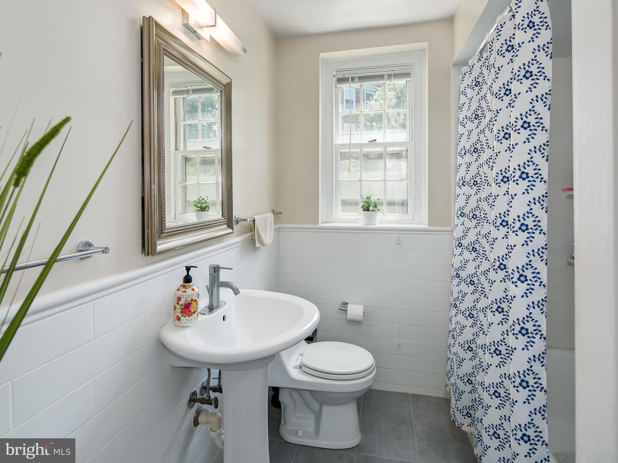 3851 Porter Street Northwest, Unit D280 Washington, DC 20016 - Photo 4 of 22 a bathroom with a sink toilet and a mirror
