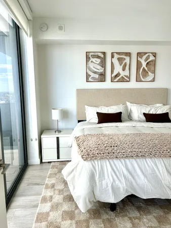 a bedroom with a bed and painting on the wall