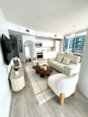 a living room with furniture and kitchen view