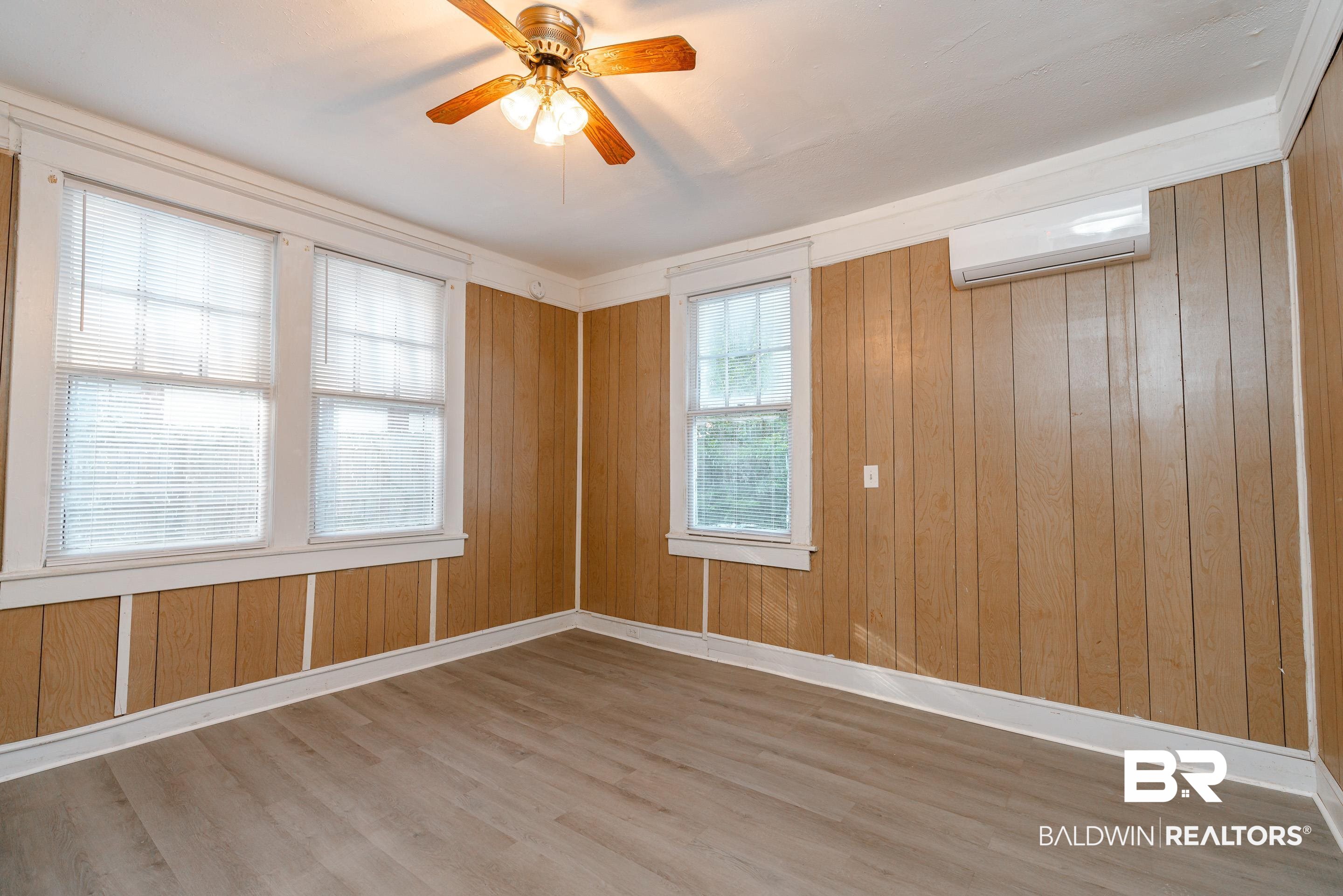 5 North Fulton Street Mobile, AL 36607 - Photo 12 of 55 Empty room featuring wood walls, ceiling fan, wood-type flooring, and a wall mounted air conditioner
