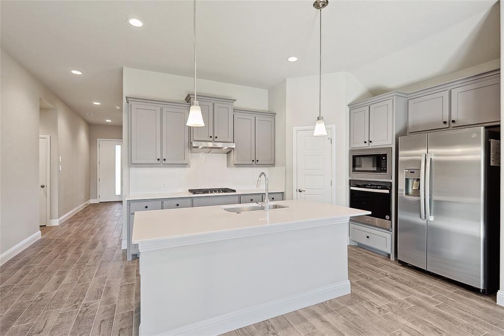 2217 Yellowhammer Road Denton, TX 76205 - Photo 14 of 30 a large kitchen with stainless steel appliances a refrigerator and a stove