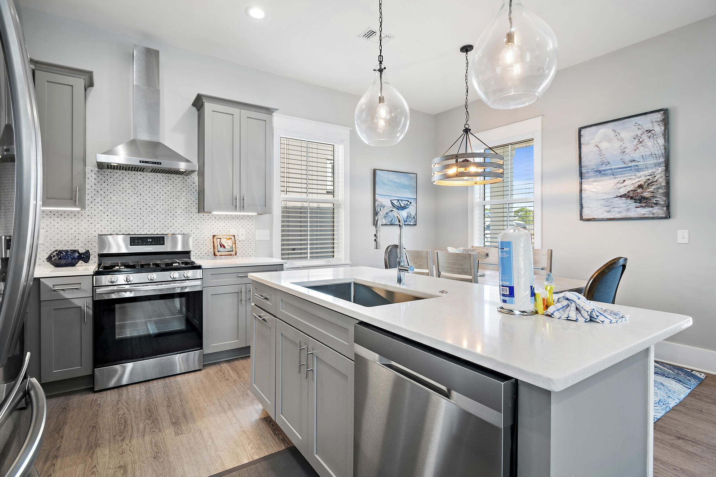 459 Dolphin Drive Santa Rosa Beach, FL 32459 - Photo 11 of 31 a kitchen with a sink stainless steel appliances a chandelier and wooden floor