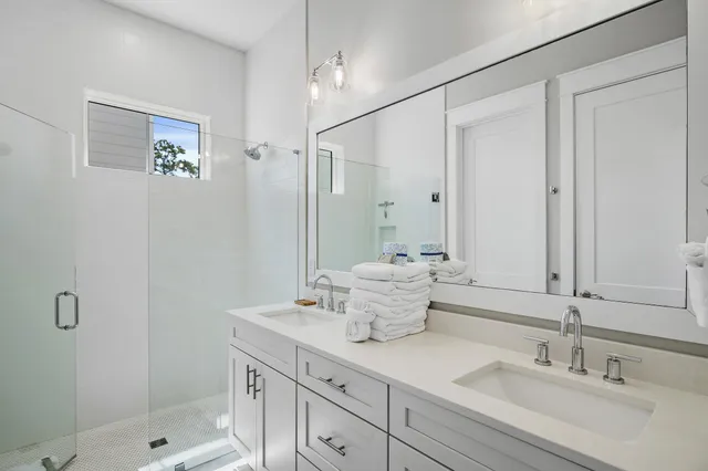 a bathroom with double sink and a mirror