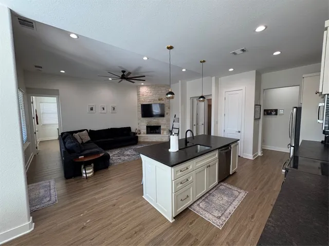 a kitchen with granite countertop a sink counter top space and living room view