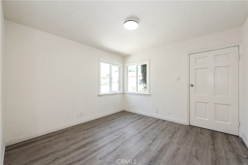 8713 Alondra Boulevard Paramount, CA 90723 - Photo 15 of 41 an empty room with wooden floor and windows