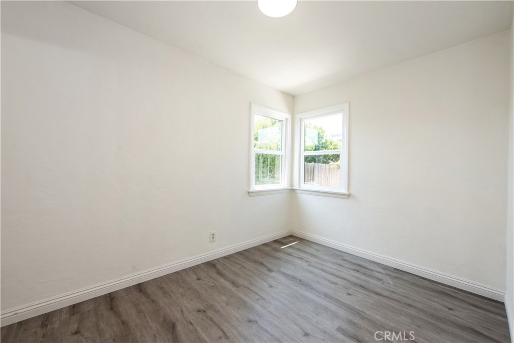8713 Alondra Boulevard Paramount, CA 90723 - Photo 17 of 41 an empty room with wooden floor and windows
