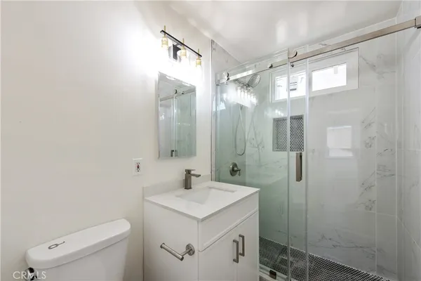 a bathroom with a sink a toilet and shower